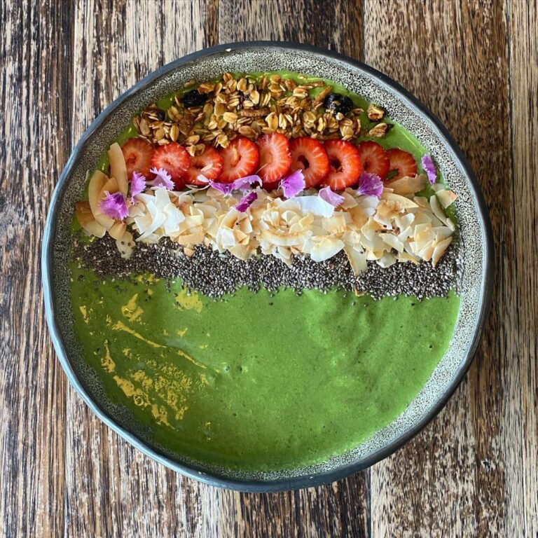 Green smoothie bowl with granola, strawberries and chia seeds