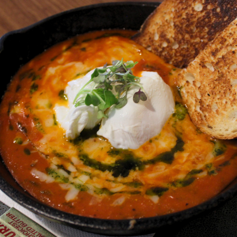 Shakshuka in a cast-iron skillet with toasted sourdough